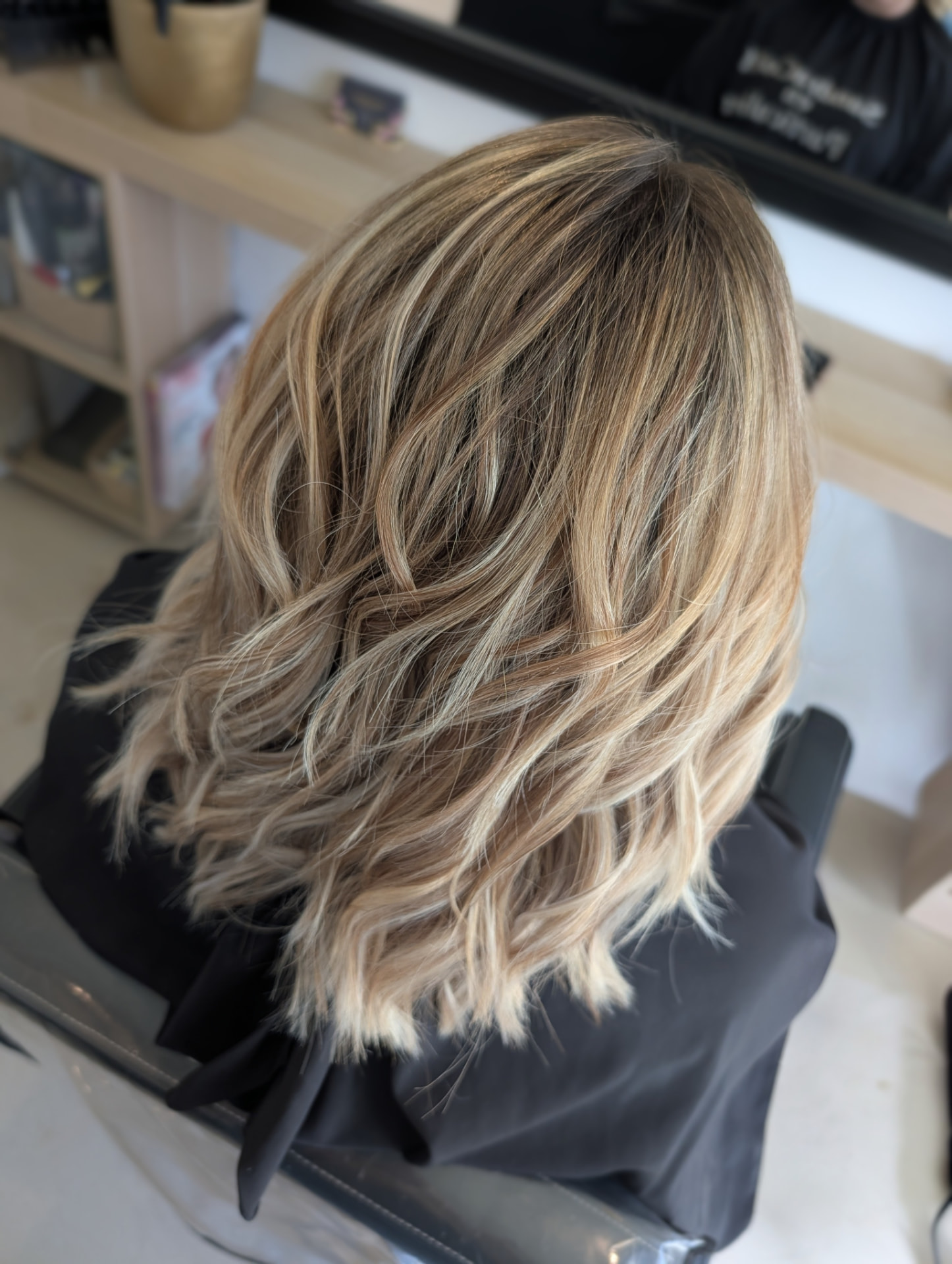 Résultat d'une coloration et coupe sur chevelure blonde, lumière chaleureuse du salon